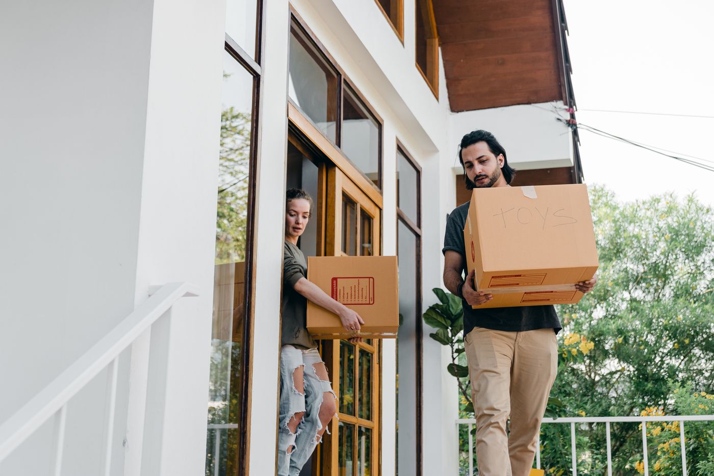 People carrying packed boxes out of a home