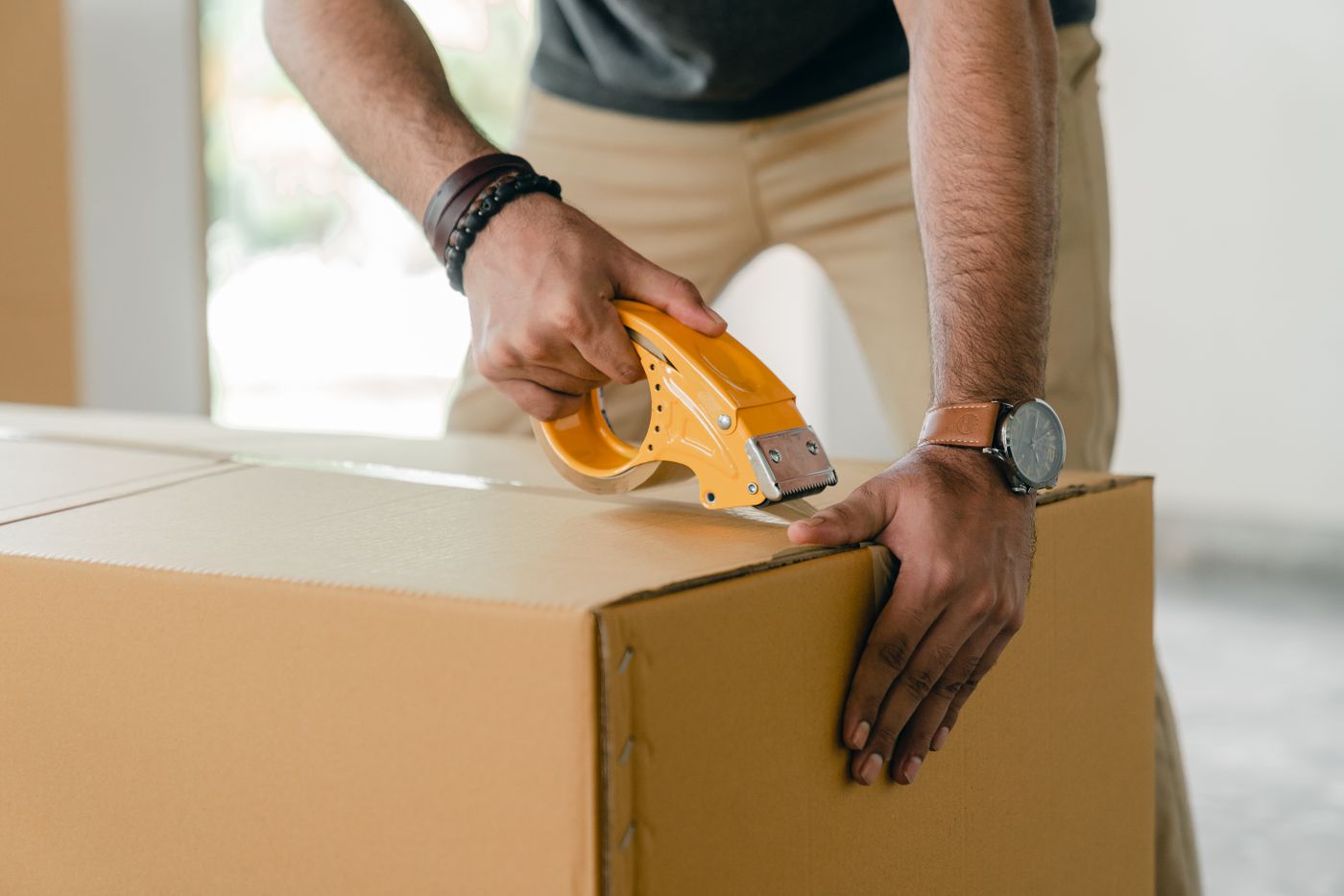 A moving box being sealed with packing tape